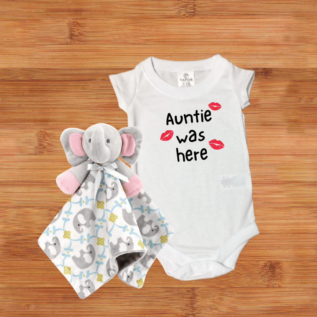 White baby bodysuit with 'Auntie was here' text and red lips design, perfect for gifting.